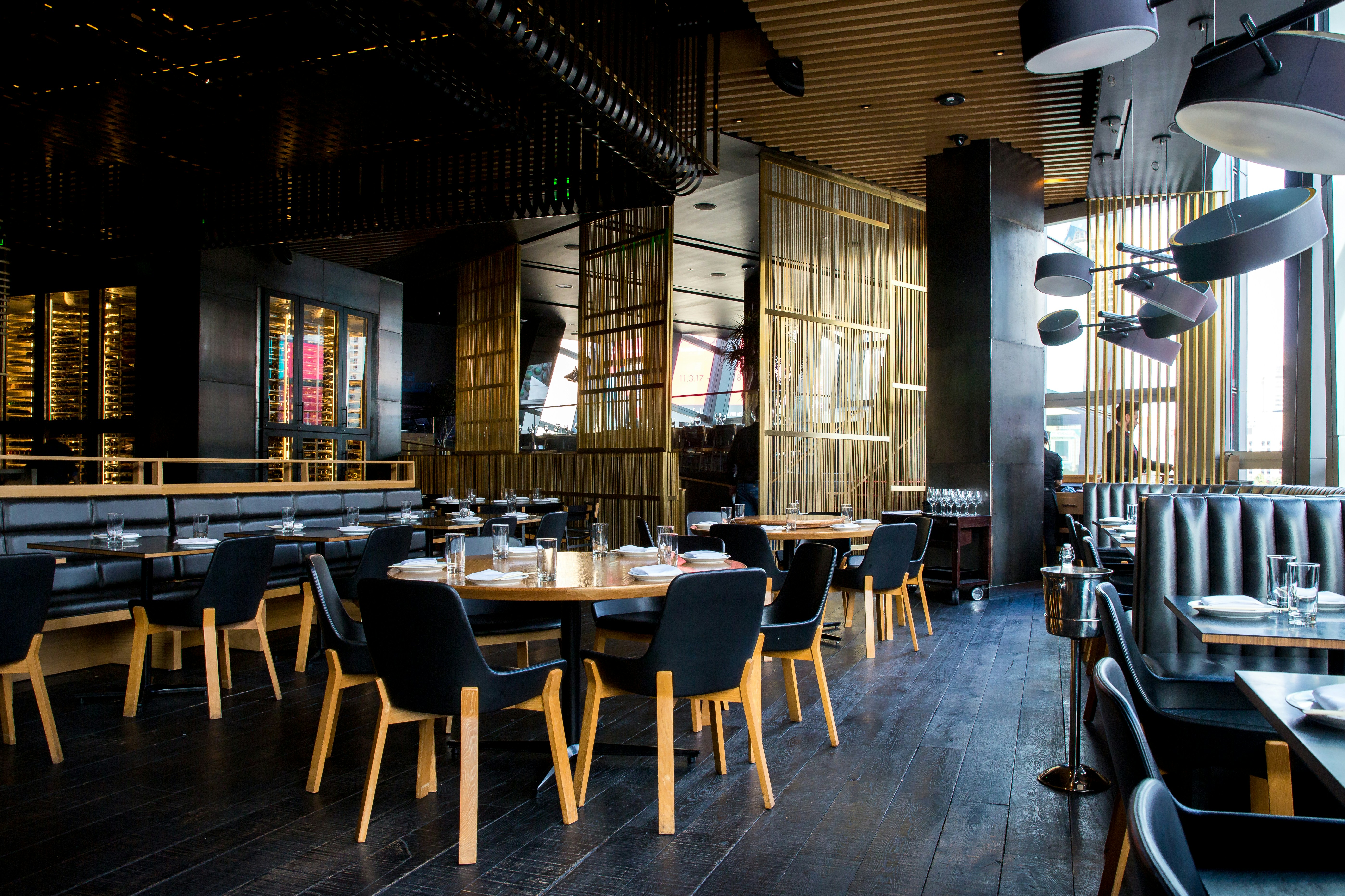 Restaurant dining room with wood tables set for service during the day